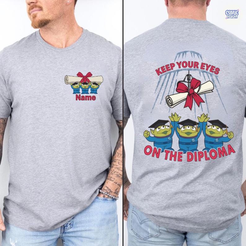 May include: A heather gray t-shirt featuring a graduation-themed design. The front displays three green alien characters holding a diploma with a red bow, with the text "Name" below. The back of the shirt reads "Keep Your Eyes On The Diploma".
