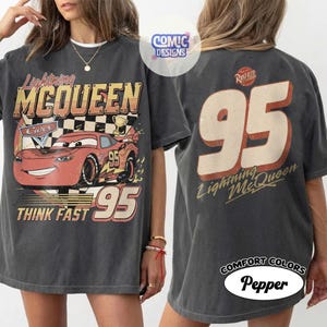 Peut inclure: T-shirt gris fonc&eacute; avec Lightning McQueen du film Cars. Le graphisme avant comprend le personnage, le num&eacute;ro 95 et les mots "Lightning McQueen" et "Think Fast". Le dos affiche un grand "95" et "Lightning McQueen".