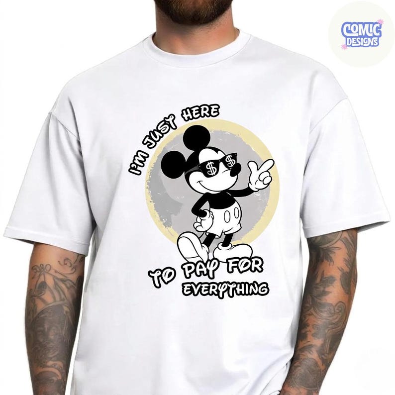 May include: White t-shirt featuring a black and white cartoon mouse wearing sunglasses with dollar signs. The text on the shirt reads "I'M JUST HERE TO PAY FOR EVERYTHING". The design is set against a light yellow circle.