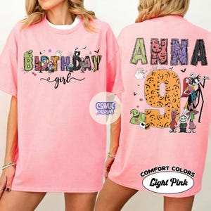 May include: A light pink t-shirt featuring a front graphic with the text Birthday girl and various cartoon characters. The back graphic displays the name Anna, the number 9, and multiple characters from The Nightmare Before Christmas movie.