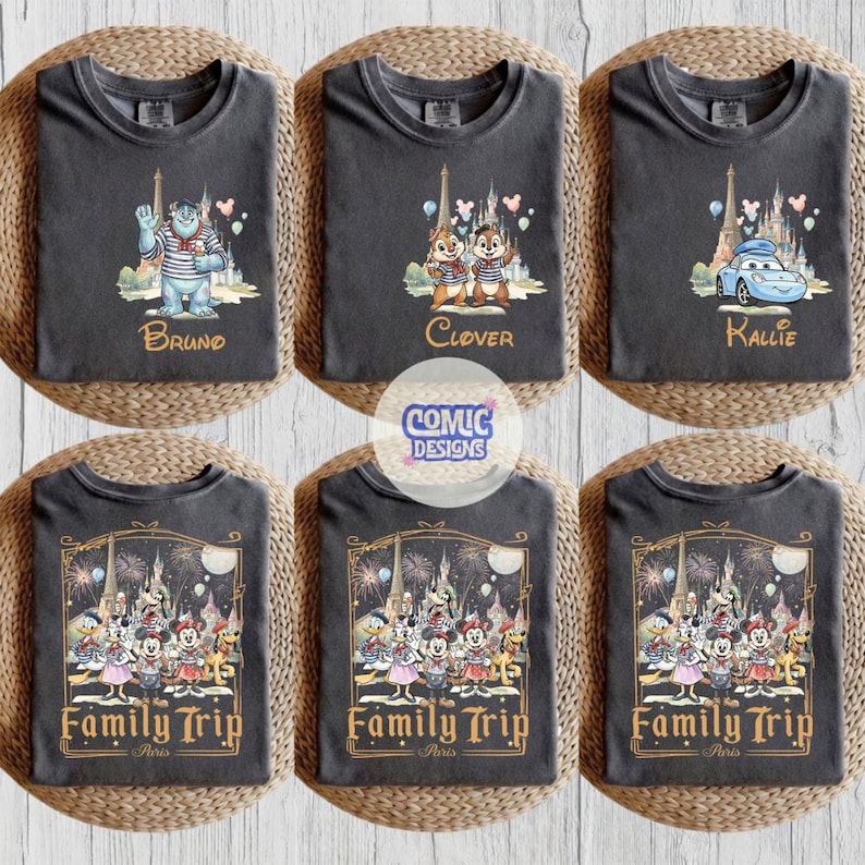 May include: Six charcoal gray t-shirts featuring Disney character graphics. The top row shows Sulley, Chip and Dale, and Lightning McQueen with names Bruno, Clover, and Kallie. The bottom row displays a group of characters with the text Family Trip Paris.