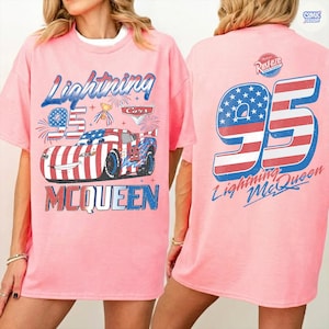 Puede incluir: Camiseta rosa con un dise&ntilde;o de Rayo McQueen de la pel&iacute;cula Cars. El frente muestra el n&uacute;mero 95, el coche en rojo, blanco y azul, y "Lightning McQueen". La parte trasera tiene un gran 95 con el dise&ntilde;o de la bandera estadounidense y "Lightning McQueen".