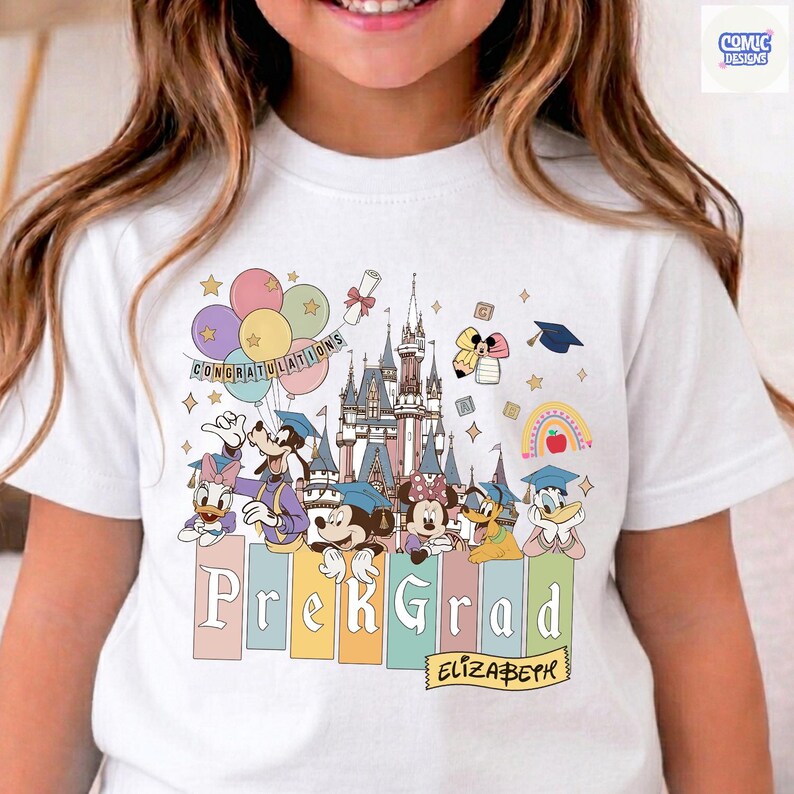 May include: White t-shirt featuring a colorful graphic of Disney characters celebrating graduation. The design includes a castle, balloons, and the words "PreK Grad" and "Congratulations". The name "Elizabeth" is also included.