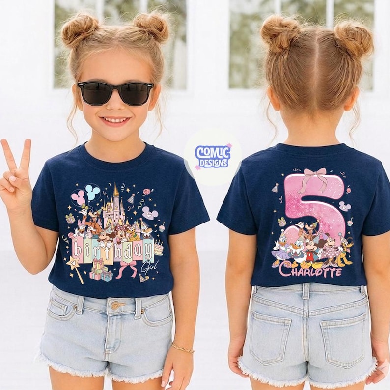 May include: Navy blue t-shirt with a colorful Disney birthday design on the front, including the text "Birthday Girl". The back of the shirt features a pink number 5 with Disney characters and the name "Charlotte".