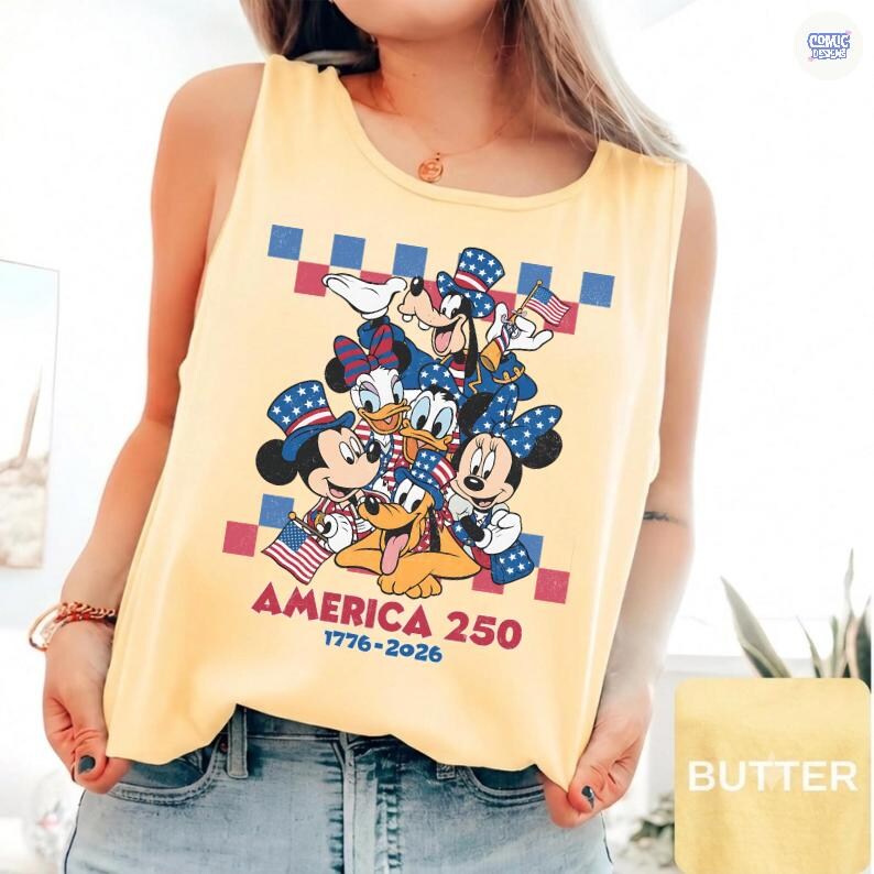 May include: A pale yellow sleeveless tank top featuring a graphic print of Mickey Mouse, Minnie Mouse, Donald Duck, Daisy Duck, Goofy, and Pluto wearing patriotic hats. The text reads AMERICA 250 1776-2026 with a red and blue checkered border.