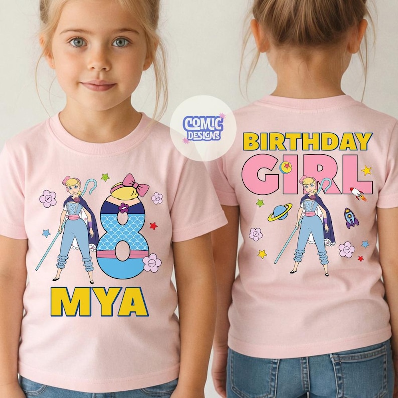 Puede incluir: Camiseta rosa claro con un dibujo animado de un personaje con un bast&oacute;n, el n&uacute;mero 8 y el nombre "MYA". La parte trasera de la camiseta dice "BIRTHDAY GIRL". La camiseta tiene cuello redondo y mangas cortas.