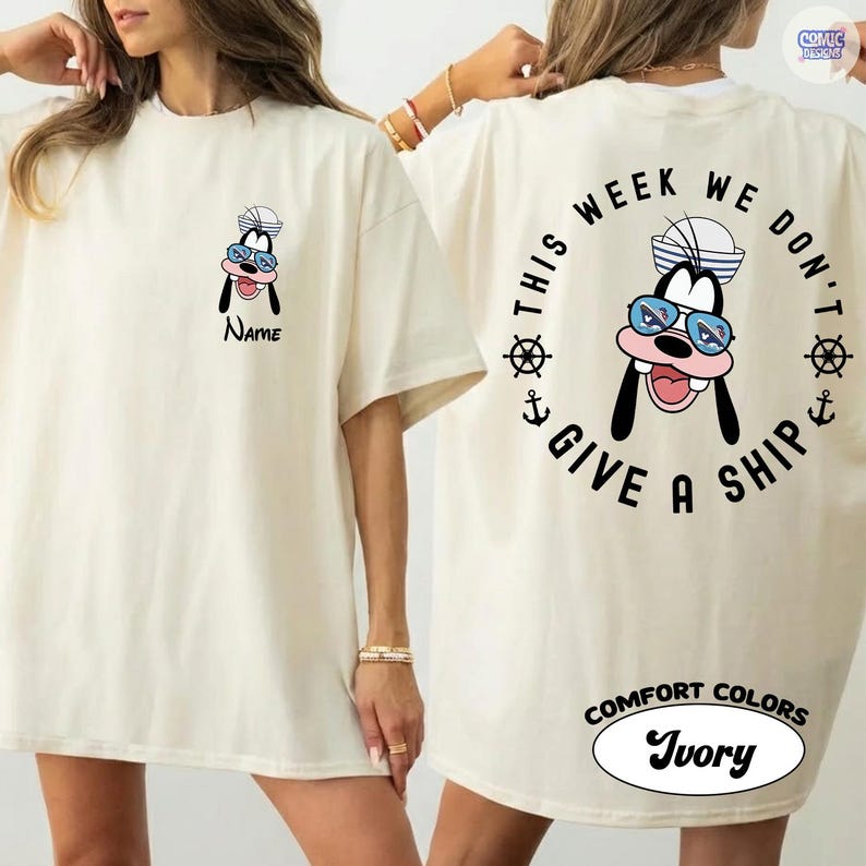 May include: Ivory-colored t-shirt featuring a cartoon character wearing a sailor hat and sunglasses. The front of the shirt has the character's face and the word "Name". The back of the shirt has the phrase "This week we don't give a ship" in a circular design.