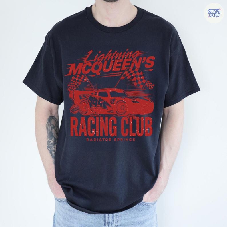 May include: Navy blue t-shirt featuring a red graphic of Lightning McQueen's Racing Club. The design includes a race car, checkered flags, and the text "Lightning McQueen's Racing Club, Radiator Springs."