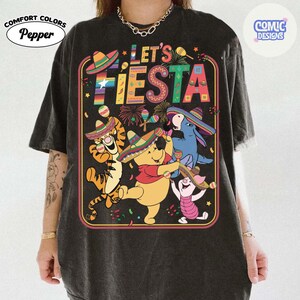 May include: Black t-shirt with a colorful "Let's Fiesta" graphic featuring cartoon characters wearing sombreros and playing maracas. The shirt has the "Comfort Colors" and "Comic Designs" logos.