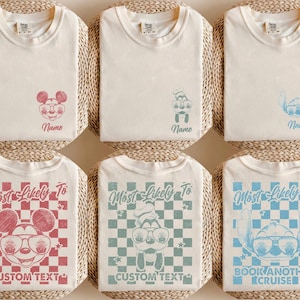 May include: Cream-colored t-shirts with cartoon character designs in red, blue, and teal. Some shirts feature the text "Name", while others say "Most Likely To" with "CUSTOM TEXT" or "BOOK ANOTHER CRUISE".