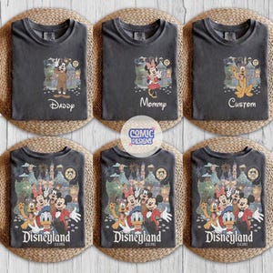 May include: A collection of six charcoal gray t-shirts featuring Disney character graphics. The top row displays individual characters with text reading Daddy, Mommy, and Custom. The bottom row shows a group scene with the text Disneyland.