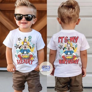 Puede incluir: Camiseta blanca con un dibujo animado de un perro sosteniendo un pastel de cumplea&ntilde;os, el n&uacute;mero 2 y el nombre "Henry". La parte trasera de la camiseta dice "It's My Birthday". La camiseta se combina con pantalones cortos marrones.