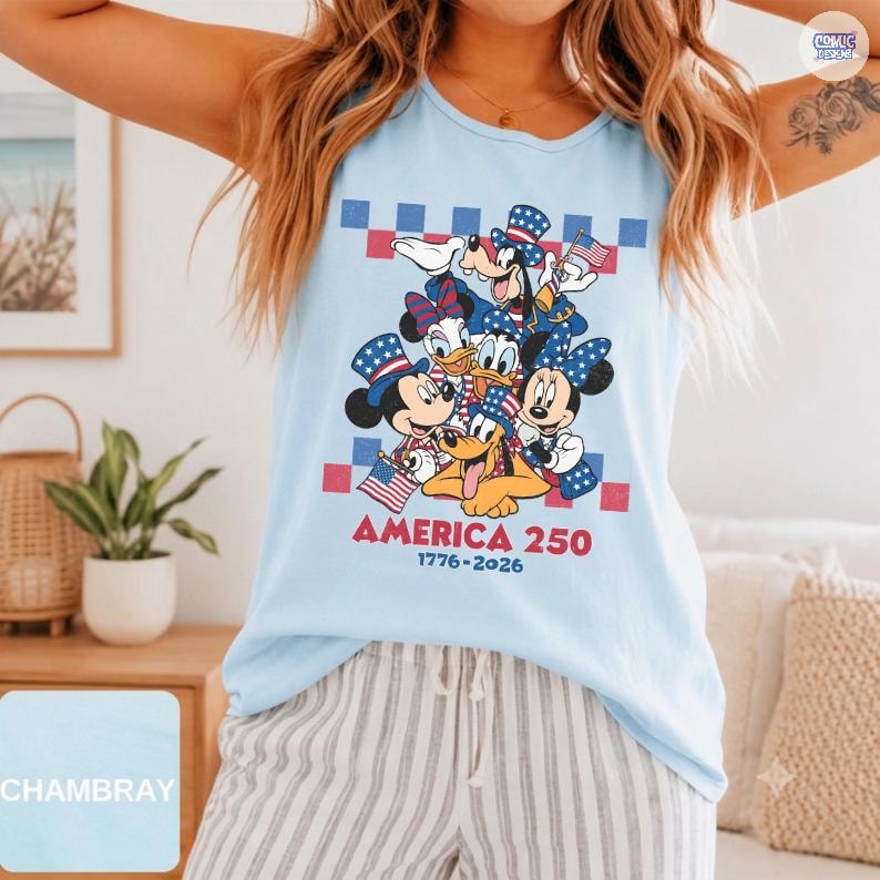 May include: A light blue sleeveless tank top featuring a graphic of Disney characters including Mickey Mouse, Minnie Mouse, Donald Duck, Daisy Duck, Goofy, and Pluto wearing patriotic hats. The text reads AMERICA 250 and 1776-2026.