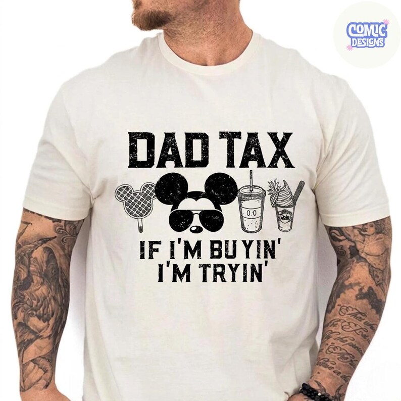 May include: Cream-colored t-shirt with the text "DAD TAX" above a Mickey Mouse graphic wearing sunglasses, and the phrase "IF I'M BUYIN' I'M TRYIN'". The shirt also features illustrations of a waffle, a drink, and a dessert.