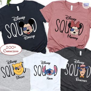 May include: A collection of Disney Squad t-shirts in various colors, including navy, pink, gray, white, and charcoal. Each shirt features a Disney character with patriotic sunglasses and the words "Daddy," "Mommy," "Sister," "Noah," and "Brother."