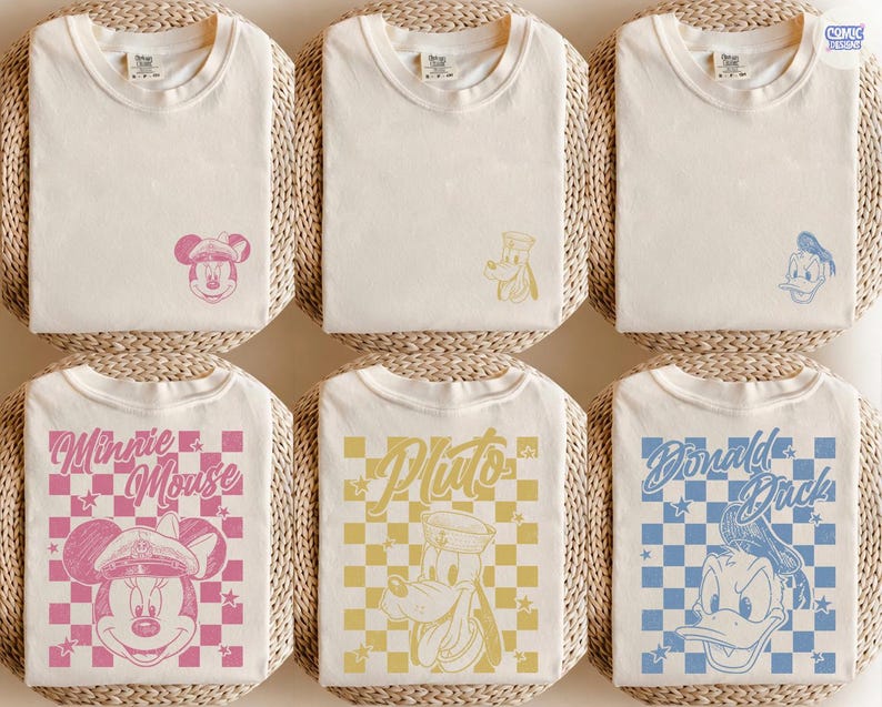 May include: Off-white t-shirts with Disney character designs. The shirts feature Mickey Mouse, Pluto, and Donald Duck, with text such as "Minnie Mouse" and "Pluto" on checkered patterns. They are displayed on woven mats.