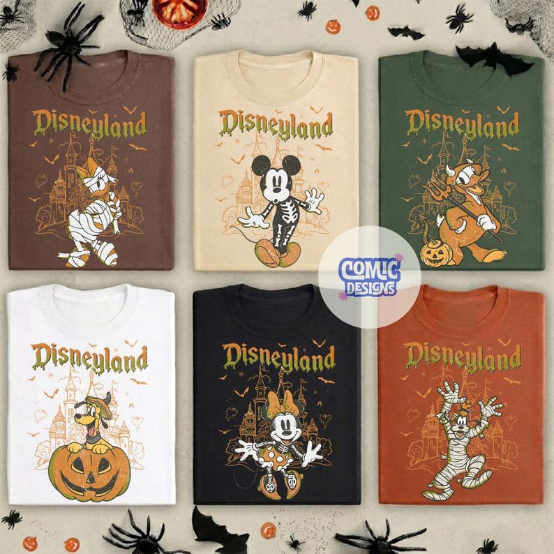 Może przedstawiać: Sześć koszulek w kolorach brązowym, kremowym, zielonym, białym, czarnym i pomarańczowym, każda z napisem Disneyland, zarysem zamku i postacią Disneya w kostiumie na Halloween, w tym mumią, szkieletem i diabłem, z nietoperzami i pająkami.
