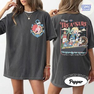 May include: Dark gray t-shirt featuring a front graphic of Ariel in a sailor's hat within a blue anchor. The back of the shirt displays a Disney Treasure design with Mickey, Donald, and other characters on a ship, with the text "Where magic meets the sea."