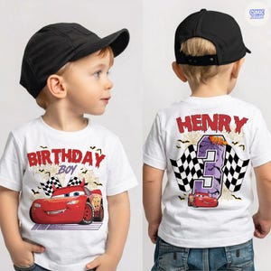 Puede incluir: Una camiseta blanca con un gr&aacute;fico de coche de carreras rojo, telara&ntilde;as, murci&eacute;lagos y el texto "BIRTHDAY BOY" al frente. La parte trasera muestra el nombre "HENRY", el n&uacute;mero "3", una bandera a cuadros y un coche rojo. Incluye una gorra negra.
