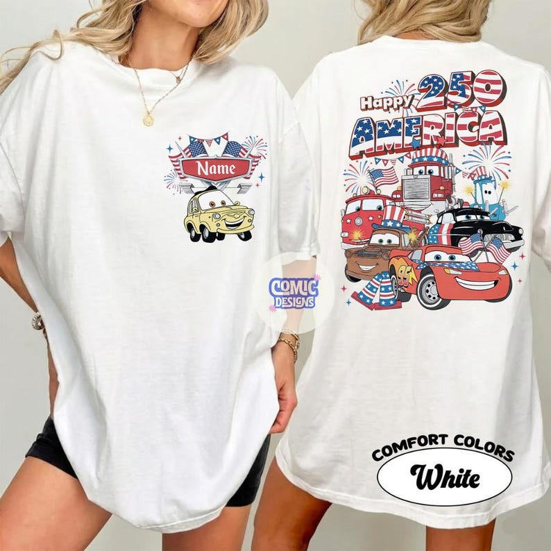 May include: White t-shirt with a patriotic design. The front features a yellow cartoon car and the word "Name" above it. The back displays "Happy 250 America" with cartoon cars, flags, and fireworks. The shirt is labeled "Comfort Colors White".