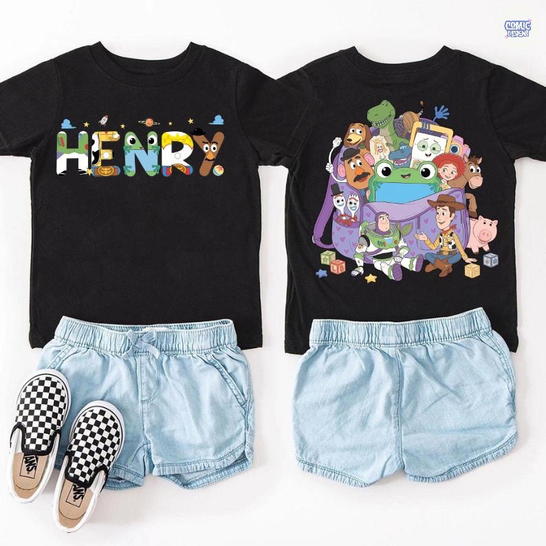 May include: Two black t-shirts and two pairs of light blue shorts. One shirt features the name HENRY in colorful patterned letters. The other shirt displays a graphic of various animated toy characters emerging from a purple backpack. A pair of black and white checkered slip-on shoes is included.