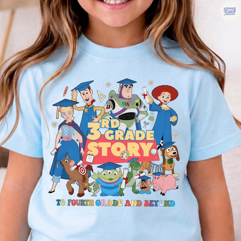 May include: Light blue t-shirt featuring a colorful graphic of animated characters with the text "3rd Grade Story" and "To Fourth Grade and Beyond". The design includes various cartoon figures in graduation attire.