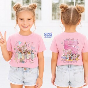 May include: A pink t-shirt featuring a colorful graphic of Disney characters, a castle, and the words "Birthday Girl." The back of the shirt displays a large number "5" with more characters and the name "Charlotte."