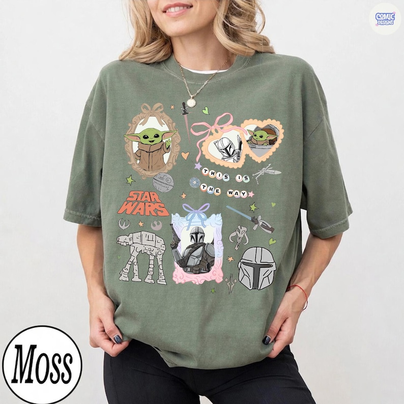 Puede incluir: Camiseta verde oliva con gr&aacute;ficos de Star Wars. El dise&ntilde;o incluye im&aacute;genes de Grogu, el Mandaloriano y un caminante AT-AT. Tambi&eacute;n est&aacute; presente el texto "This is the Way". La camiseta tiene un corte holgado.