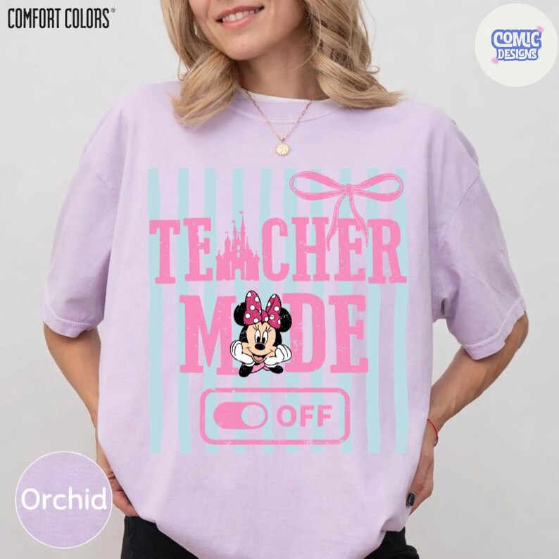 May include: Orchid-colored t-shirt with the words "TEACHER MODE OFF" in pink, featuring a Minnie Mouse graphic. The design includes light blue vertical stripes and a pink bow. The shirt is from Comfort Colors.