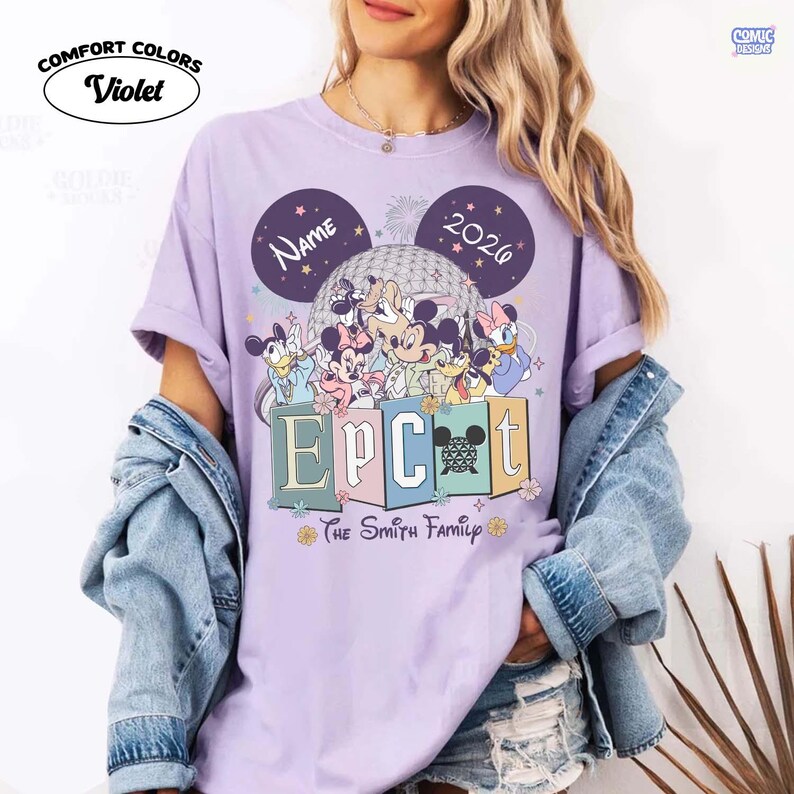 May include: Violet Comfort Colors t-shirt featuring a Disney-themed design. The design includes Mickey Mouse, Minnie Mouse, Donald Duck, and other characters, with the text "EPCOT" and "The Smith Family". The shirt also has the text "NAME" and "2026".