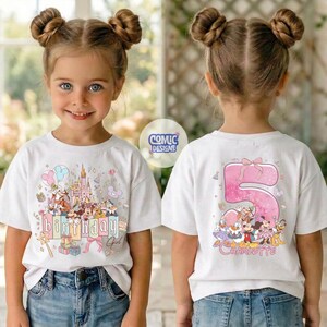 May include: White t-shirt with a colorful graphic featuring a castle, balloons, and cartoon characters. The front of the shirt says "Birthday Girl". The back of the shirt has a large pink number 5 and the name "Charlotte".