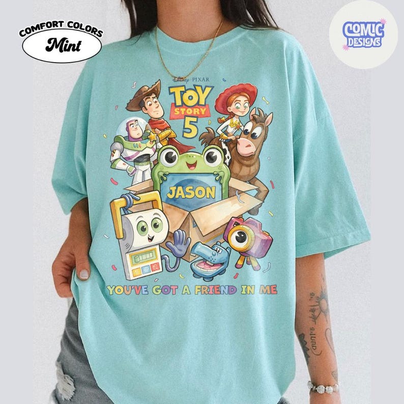 May include: A mint green t-shirt featuring a Toy Story 5 graphic with characters Woody, Buzz Lightyear, Jessie, Bullseye, and others. The design includes a central box with the name Jason, the text Toy Story 5, and You've Got A Friend In Me.