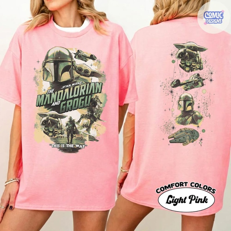 Puede incluir: Camiseta rosa claro con un dise&ntilde;o de la serie Star Wars, "The Mandalorian y Grogu." La parte delantera muestra el t&iacute;tulo y los personajes, mientras que la trasera presenta im&aacute;genes adicionales. La camiseta tiene el texto "This is the Way."