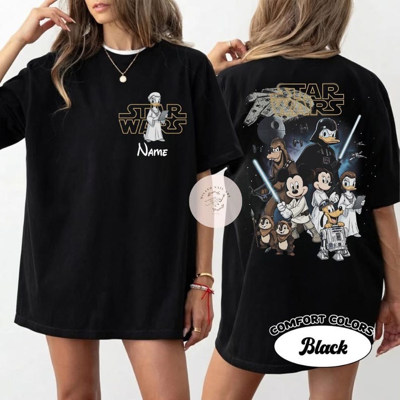 May include: Black t-shirt featuring a Star Wars-themed design. The front displays a cartoon character with the Star Wars logo and the word "Name". The back showcases various characters, the Star Wars logo, and the text "Comfort Colors Black".