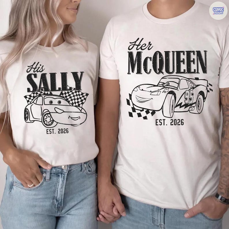 May include: Matching white t-shirts with black graphics. One shirt says "His SALLY" with a cartoon car and checkered flag, the other says "Her McQUEEN" with a cartoon car and checkered flag. Both shirts have "EST. 2026".
