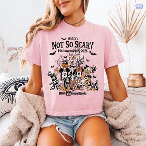 May include: A light pink t-shirt with the text "Mickey's Not So Scary Halloween Party 2026" and a graphic of Disney characters in skeleton costumes. The Walt Disney World logo is at the bottom of the graphic.