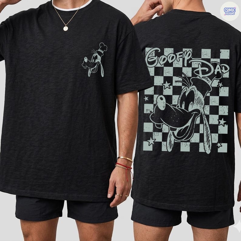 May include: Black t-shirt featuring a cartoon image of Goofy wearing a chef's hat on the front and back. The back of the shirt has the words "Goofy Dad" in a checkered pattern with stars. The shirt is made of a soft material.