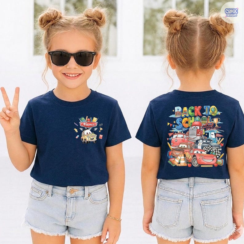 May include: A navy blue short-sleeve t-shirt featuring a small graphic on the front left chest of a cartoon race car with school supplies and the text Name. The back displays a large colorful graphic of race cars with the text Back To School.
