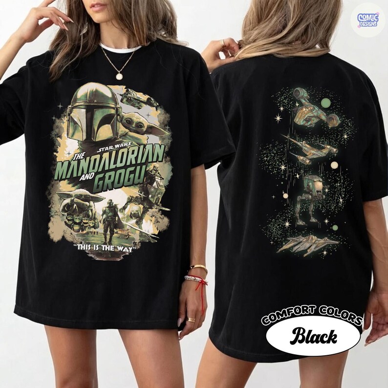 Op de afbeelding: Zwart T-shirt met een ontwerp van The Mandalorian en Grogu. De voorkant heeft een afbeelding met de tekst "THIS IS THE WAY". De achterkant toont schepen en personages in een ruimtethema.