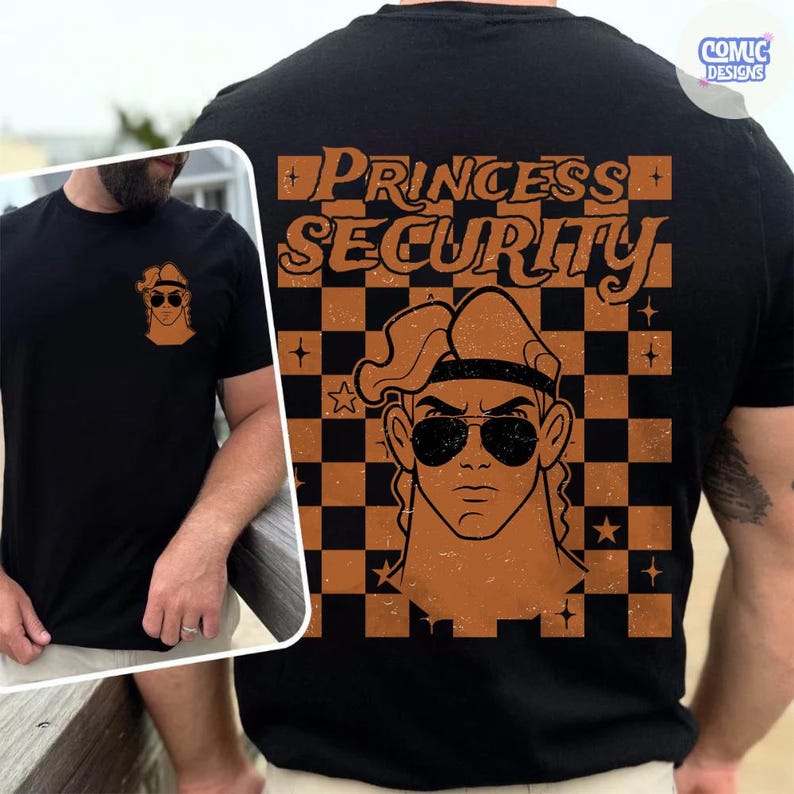 May include: Black t-shirt with a graphic of a cartoon character wearing sunglasses and the words "PRINCESS SECURITY" in orange. The design is on the back and a smaller version is on the front. The shirt has a crew neck.