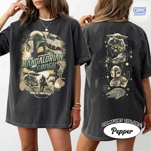 Puede incluir: Camiseta gris oscuro con un gr&aacute;fico de "The Mandalorian and Grogu". El dise&ntilde;o frontal incluye el texto "The Mandalorian and Grogu" y "This is the Way". El dise&ntilde;o trasero presenta a Grogu, el Mandaloriano y naves espaciales.