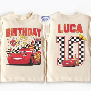 May include: Cream-colored t-shirt featuring a red race car graphic from the movie Cars. The front of the shirt says "BIRTHDAY Boy" with balloons and confetti. The back of the shirt says "LUCA 10" with a checkered pattern.