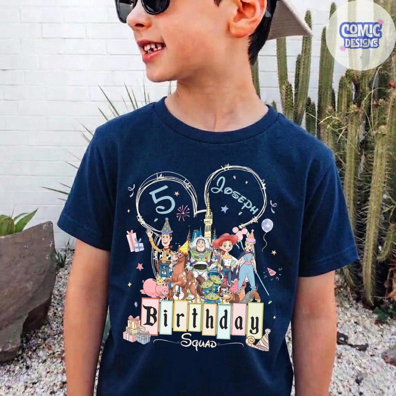 May include: Navy blue t-shirt featuring a colorful graphic of Toy Story characters. The shirt has the text "5 Joseph Birthday Squad" in a playful font. The design includes stars, balloons, and gift boxes, perfect for a birthday celebration.