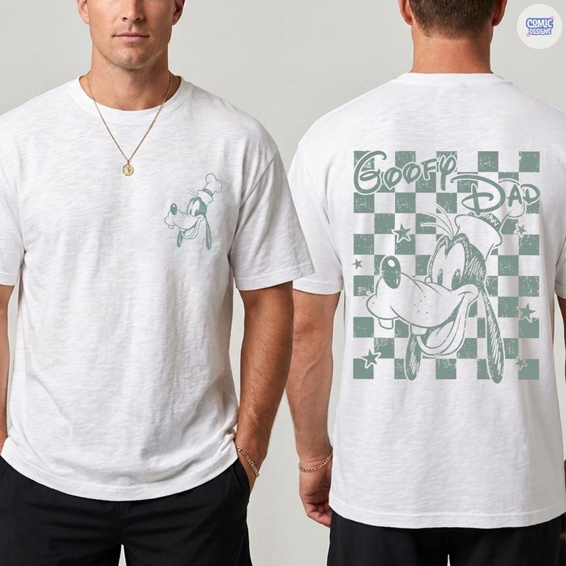 May include: White t-shirt featuring a cartoon image of Goofy wearing a chef's hat on the front pocket and a larger image on the back with the text "Goofy Dad" over a checkered background. The shirt is a casual style.