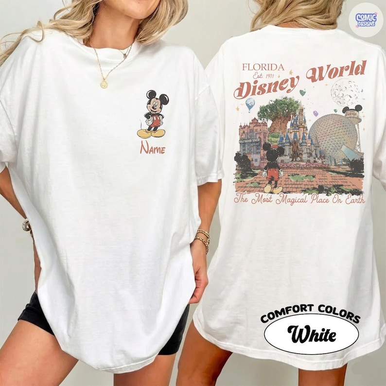 K&ouml;nnte beinhalten: Wei&szlig;es T-Shirt mit Mickey Mouse auf der Vorderseite und einem Disney World-Motiv auf der R&uuml;ckseite. Auf der Vorderseite ist Mickey und das Wort "Name" zu sehen. Auf der R&uuml;ckseite stehen die Worte "Florida Disney World" und "The Most Magical Place On Earth".