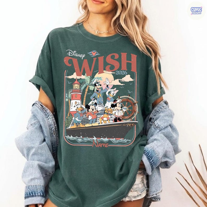 Puede incluir: Camiseta verde oscuro con un dise&ntilde;o de personajes de Disney en un crucero con el texto "Disney Wish 2026". El dise&ntilde;o incluye a Mickey Mouse, el Pato Donald y Goofy. La camiseta tiene un aspecto vintage.
