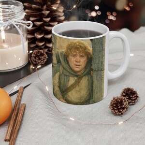 May include: White ceramic mug featuring a character from a fantasy film. The mug has a handle and is filled with a dark liquid. The image on the mug depicts a person with fair skin and curly hair. The mug is surrounded by decorative items.