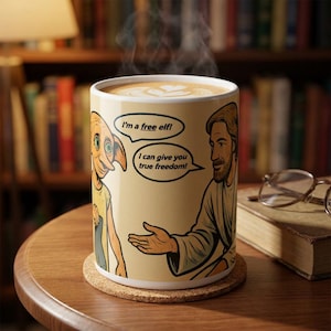 May include: A ceramic coffee mug with a cartoon illustration of a character saying "I'm a free elf!" and another character saying "I can give you true freedom!". The mug is filled with coffee and sits on a cork coaster.