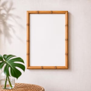 Puede incluir: Un marco de fotos rectangular con un acabado estilo bambú de color marrón claro y un centro blanco liso. El marco presenta nudos horizontales distintivos a lo largo de sus bordes, imitando la apariencia natural de los tallos de bambú en vertical.