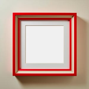 May include: A square picture frame with a vibrant red outer edge and a cream-coloured inner frame. The frame has a white mount around the centre, which is empty. The frame is mounted on a light beige wall.